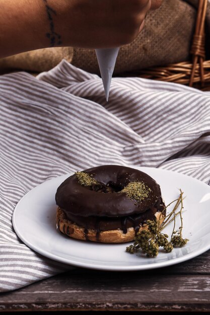 Delicioso donut con salsa de chocolate y trocitos de pistacho