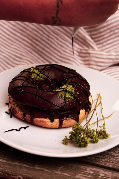 Delicioso donut con salsa de chocolate y trocitos de pistacho.