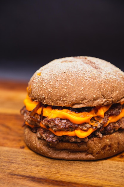 Delicioso duplo hambúrguer bovino com queijo cheddar e cebola caramelizada hambúrguer bovino pão australiano