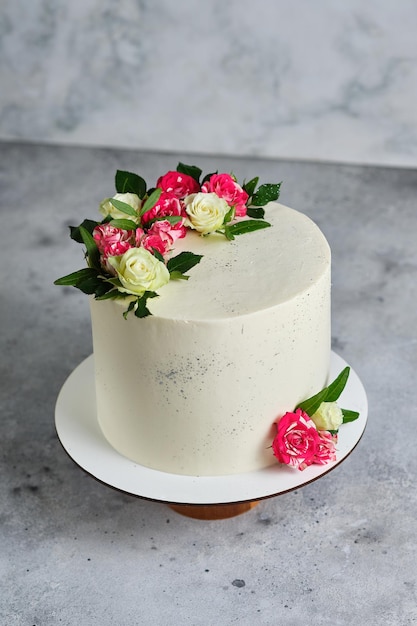 Delicioso e lindo bolo artesanal. confeitaria de casamento. o bolo branco é decorado com flores rosas naturais.