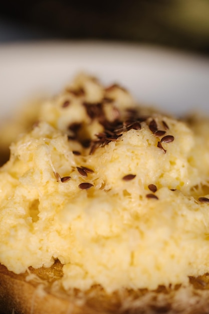 Delicioso e lindo café da manhã Torradas com mexidos por cima polvilhadas com especiarias e sementes de linho Foto macro