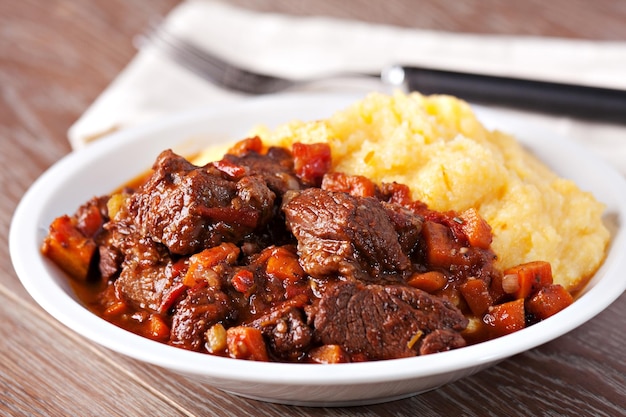 Foto delicioso ensopado de carne com cogumelos e polenta foto de alta qualidade