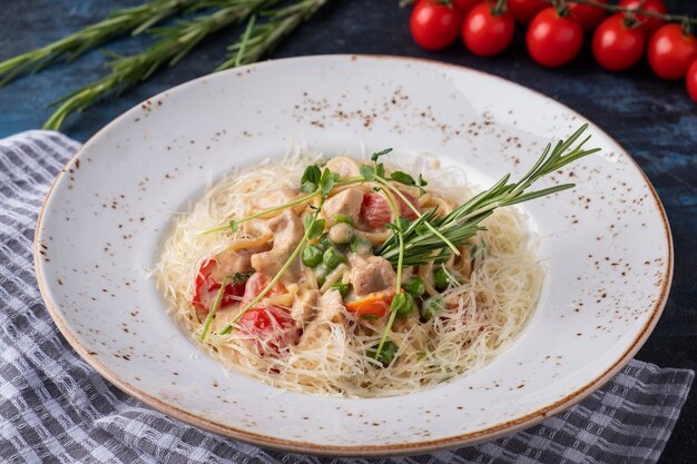 Delicioso espaguete com frango, legumes e queijo em um prato