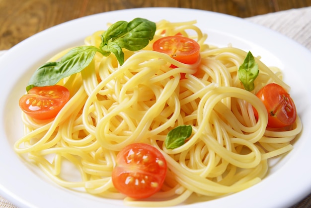 Delicioso espaguete com tomate no prato na mesa closeup