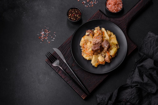 Delicioso estofado de verduras con patatas zanahorias y repollo en un plato negro