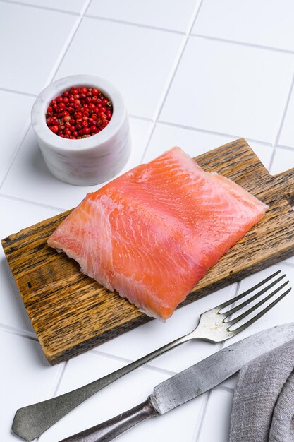 Delicioso filé de salmão rico em óleo ômega 3 sobre fundo de mesa de cerâmica branca quadrada