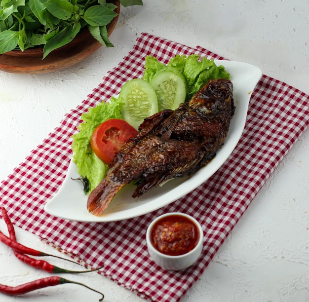 Delicioso frango e peixe grelhados na hora é apetitoso servido em um prato de madeira