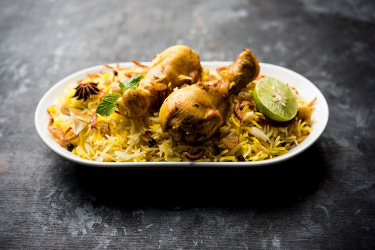 Foto delicioso frango picante biryani em uma tigela sobre fundo temperamental, é uma comida popular indiana e paquistanesa