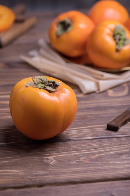 Delicioso fruto de caqui laranja fresco na mesa de madeira com uma faca