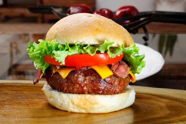 Delicioso hambúrguer com carne, alface, tomate, bacon e queijo cheddar