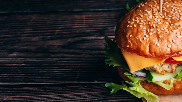 Foto delicioso hambúrguer suculento com carne, queijo, alface, tomate e cebola