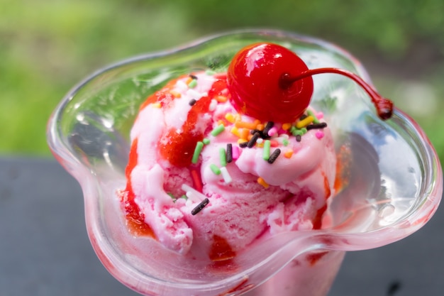 Foto delicioso helado con una cereza roja.