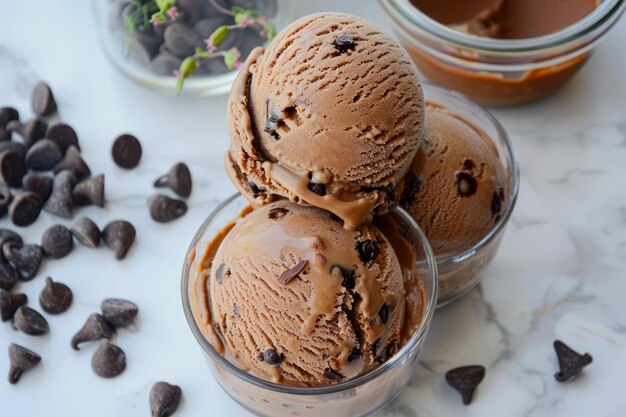 Delicioso helado de chocolate en un cuenco de vidrio sobre un fondo de mármol blanco con ingredientes