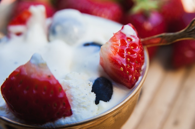 Delicioso helado con trozos de fresa y arándanos