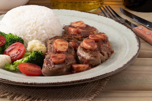 Delicioso lomo con arroz con salsa de champiñones y plato de ensalada