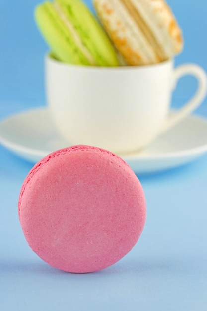 Delicioso macaron e uma xícara de biscoitos coloridos