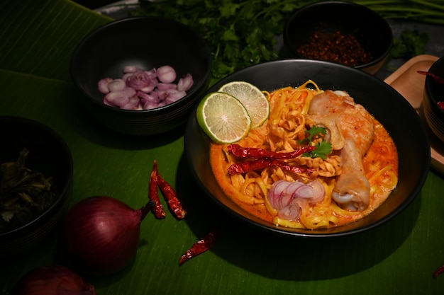 Delicioso macarrão de curry tailandês com coxa de frango e legumes ou Khao Soi Kai