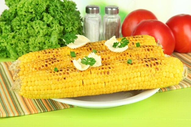 Foto delicioso maíz dorado a la parrilla con mantequilla en la mesa sobre fondo brillante