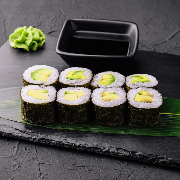 Delicioso maki de sushi con aguacate en negro