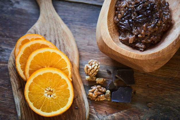 Delicioso mingau de arroz com chocolate e nozes em uma tigela de madeira