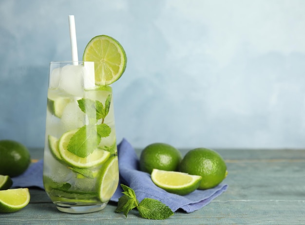 Delicioso mojito e ingredientes na mesa de madeira azul Espaço para texto