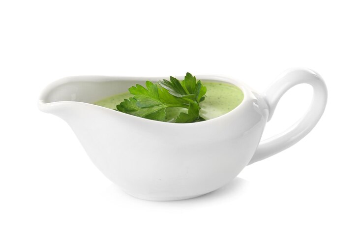 Foto delicioso molho de iogurte com folhas de salsa em molheira isolada em branco