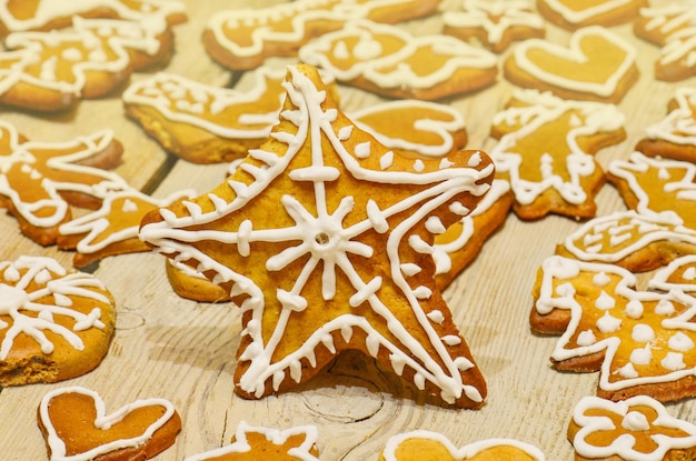 Delicioso natal estrela de gengibre em fundo de madeira. plano de fundo de natal ou ano novo com biscoitos de gengibre