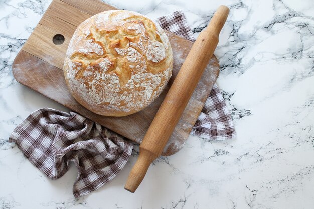 Delicioso pan recién horneado sobre tabla de madera