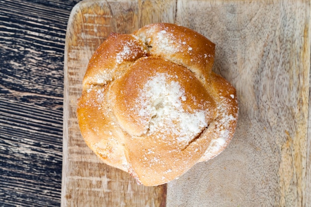 Delicioso pão com cobertura em uma tábua de madeira, 1 peça