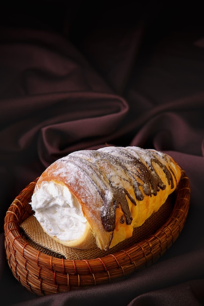 Delicioso pão em forma de cone enrolado recheado com creme de confeiteiro coberto com chocolate caseiro