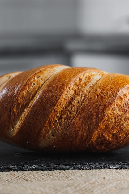 Delicioso pão redondo de centeio fresco sobre um fundo escuro Pão fresco crocante Pão acabado de cozer