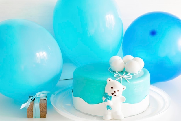 Delicioso pastel azul bebé decorado con globos, oso para la celebración del primer cumpleaños del niño. con colores azules para baby shower para niño.