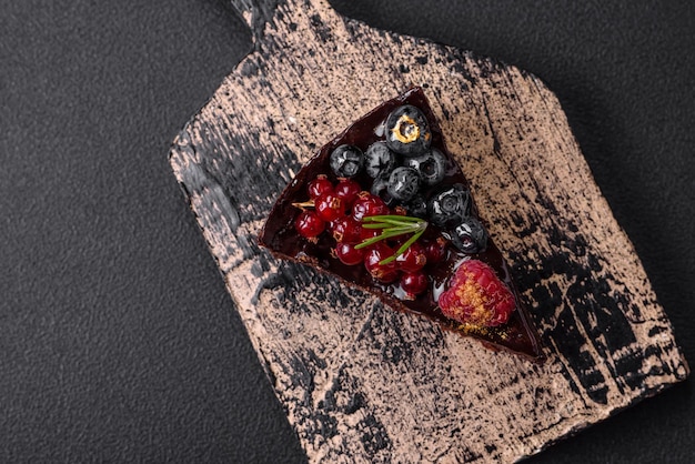 Delicioso pastel de brownie de chocolate dulce con arándanos, grosellas y frambuesas en un plato de cerámica