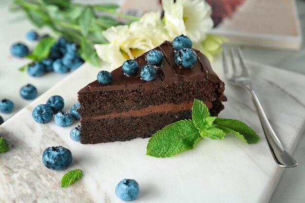 Delicioso pastel de chocolate con arándanos en tablero de piedra