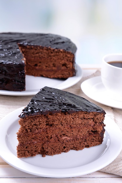 Delicioso pastel de chocolate en la placa en la mesa sobre fondo claro