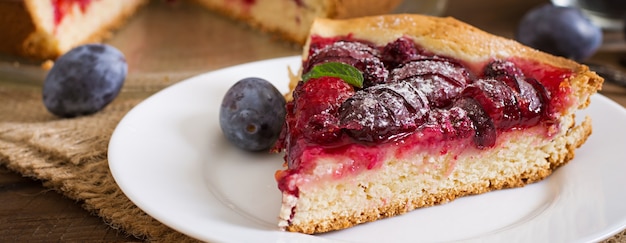 Delicioso pastel con ciruelas frescas y frambuesas