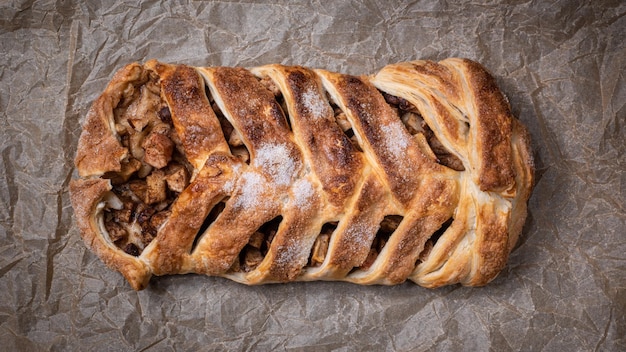 Delicioso pastel de coleta dulce casero con manzanas en la vista superior de pergamino para hornear