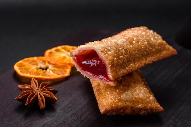 Delicioso pastel crujiente fresco con mermelada de cereza en una tabla de cortar de madera