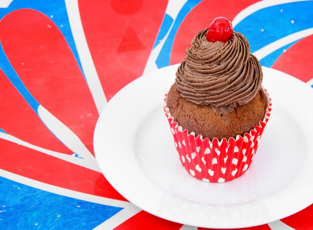 Un delicioso pastel cubierto con crema y un cupcake sobre un fondo de madera rústica