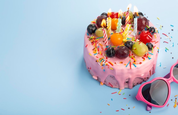 Delicioso pastel de cumpleaños fresco con velas en la mesa con fondo de color