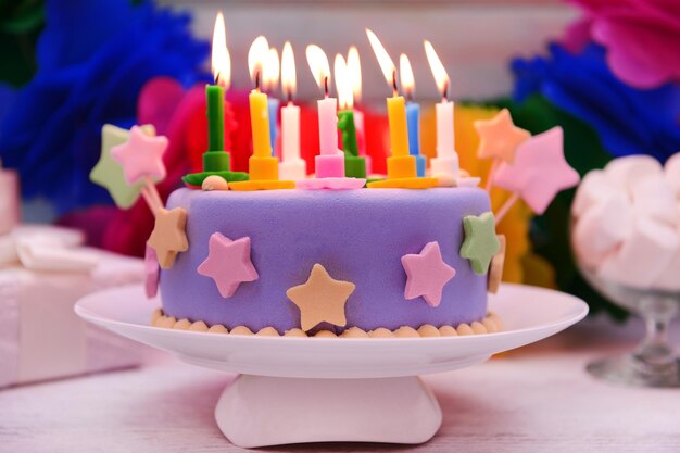 Foto delicioso pastel de cumpleaños en la mesa sobre fondo brillante