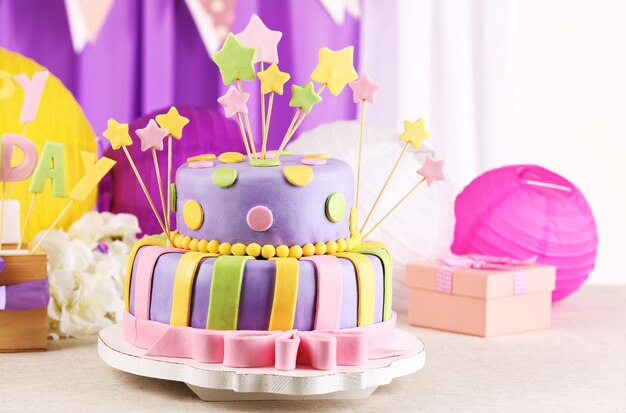 Foto delicioso pastel de cumpleaños en la mesa sobre fondo brillante