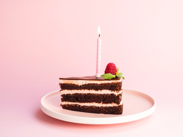 Delicioso pastel de cumpleaños sobre fondo rosa