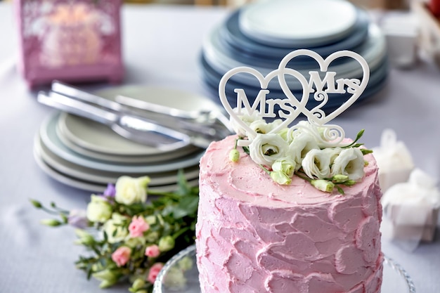 Delicioso pastel decorado con flores y corazones para boda lesbiana