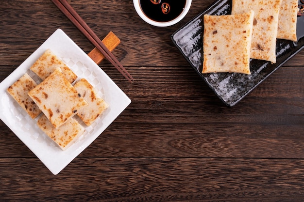 Delicioso pastel de nabo pastel de rábano tradicional chino en restaurante con salsa de soja para platos de año nuevo cerrar espacio de copia vista superior plano