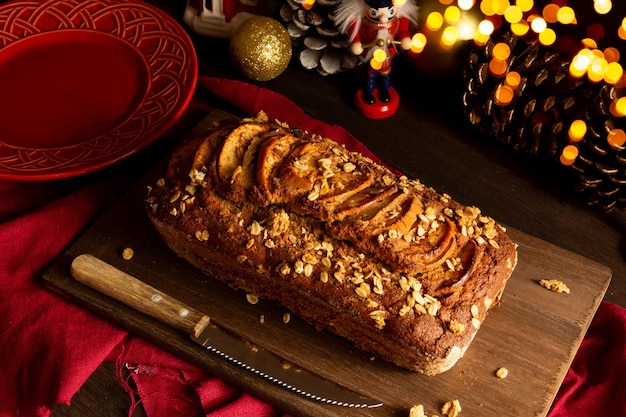 Delicioso pastel navideño de manzana y avena en una mesa de madera con luces bokeh y decoración navideña