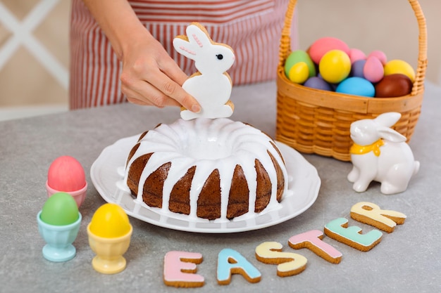 Foto delicioso pastel de pascua con galletas de conejo rodeado de huevos coloridos y letras de galletas