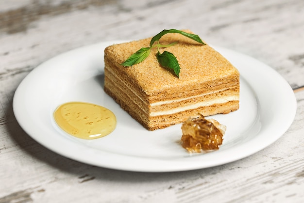 Delicioso pastel en plato blanco sobre mesa de madera