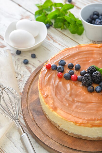 Delicioso pastel de queso con frutos rojos en la mesa