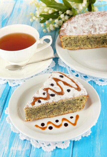 Delicioso pastel de semillas de amapola con una taza de té en la mesa de primer plano